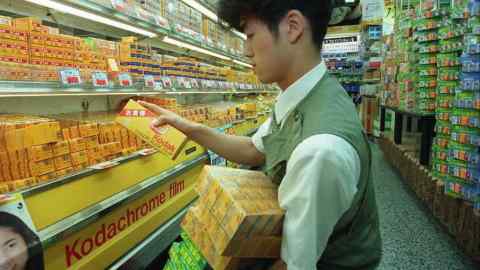 A sales clerk stacks Kodak film in a camera shop in Tokyo