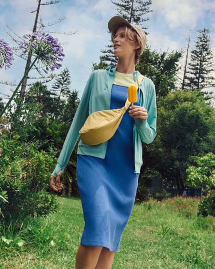 A young woman wearing a fairly small, yellow,  banan shaped shoulder bag across her body