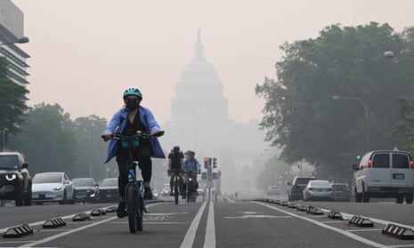 A cyclist rides under a blanket of haze partially obscuring the US Capitol in Washington, DC, on June 8, 2023.