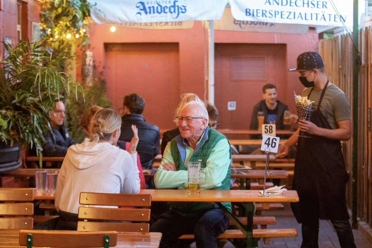 Michael Mandl (sitting, facing camera) enjoys a beer with his family at Gourmet Haus Staudt in Redwood Calif., on January 14, 2022.