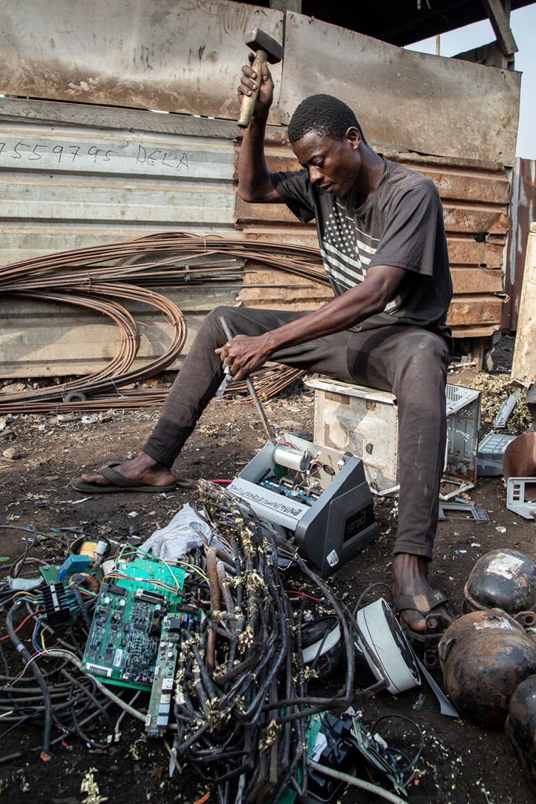 Nurideen, 35, is breaking down an old battery charger inverter