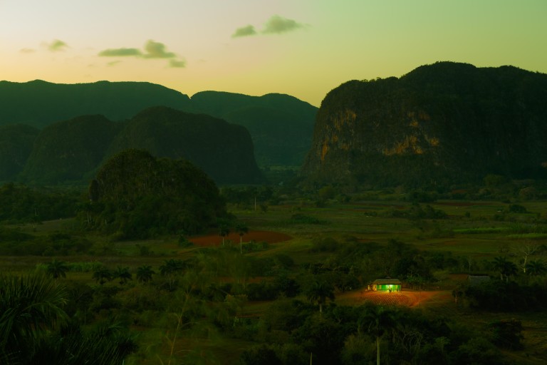 A family rests in front of their house in the stunning Viñales valley