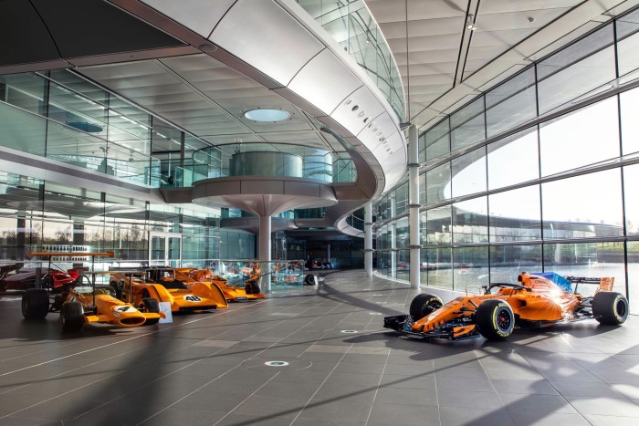 Six papaya-coloured Formula One cars and a long curved glass wall greet visitors   