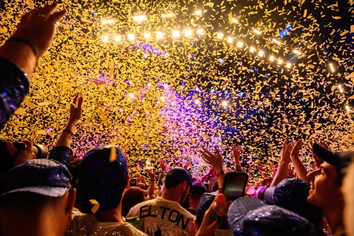 Colourful confetti rains down against a night sky