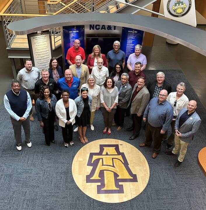 Defense Civilian Training Corps leadership group viewed from above for a photo with the A&T logo on the ground in front of them