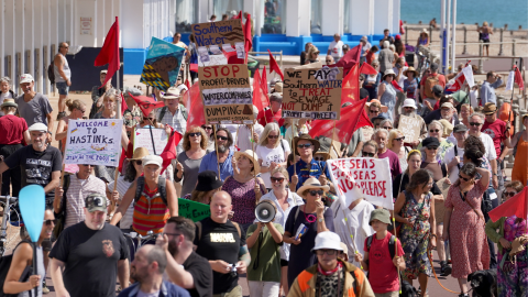 Protesters holding sings and banners near the beach