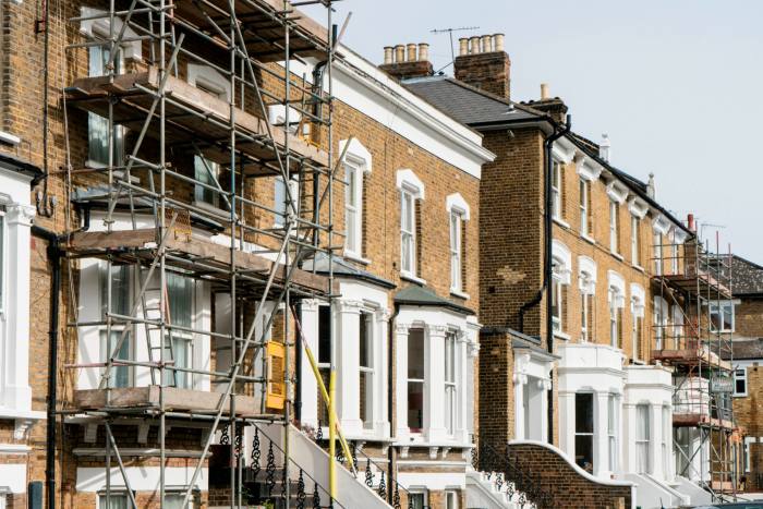 A row of terraced houses with two properties covered in scaffolding