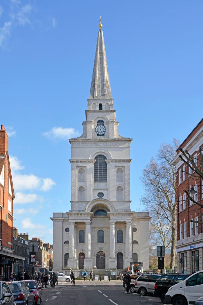 A white church with four columns at the entrance and a steeple