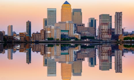 Pink sunset at Canary Wharf and its reflection from river Thames in London.