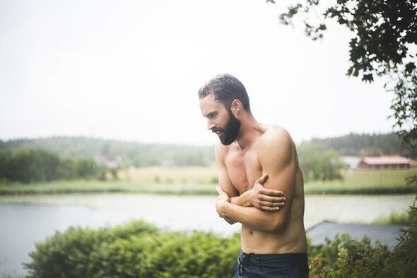 A topless man shivering