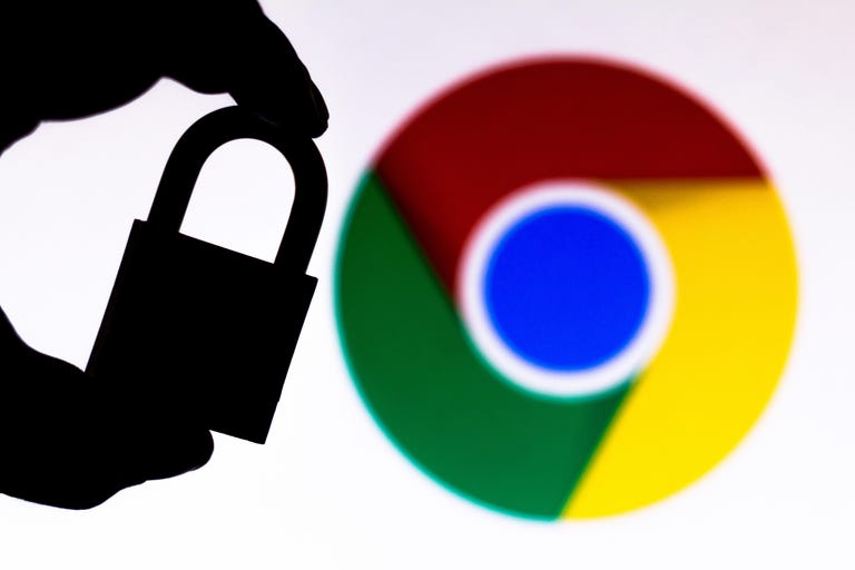 A hand holding a lock with the Google Chrome logo in the background