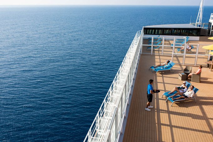 Guests relax in deck chairs and enjoy the sun onboard a Costa cruise ship.