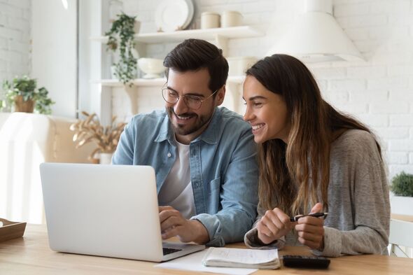 Couple smiling assessing finances