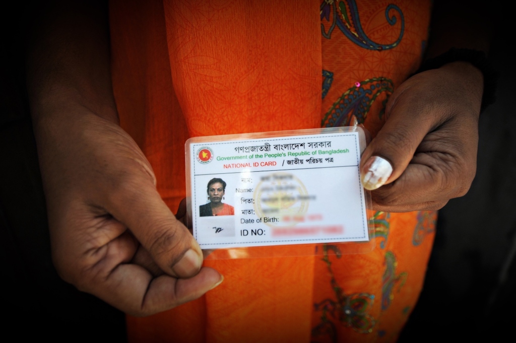 a photo of a Bangladeshi national ID card held up to the camera (with identifying data blurred)