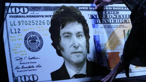 Argentina presidential candidate Javier Milei's sister Karina Milei places a picture of her brother on a 100-dollar cardboard bill before the start of the presentation of her brother's book "The End of Inflation" at the Buenos Aires book fair in Buenos Aires, Argentina, Sunday, May 14, 2023. (AP Photo/Natacha Pisarenko)