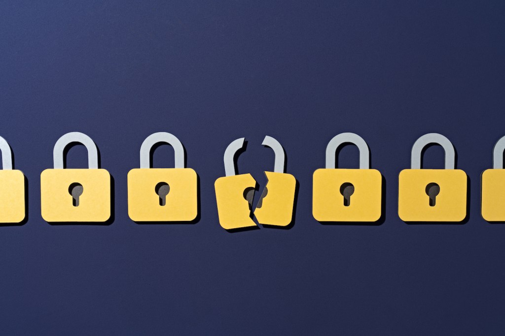 Paper Craft of a Cracked Yellow Padlock in a Group of Secure Ones on Purple Background Front View, Data Security Concept.