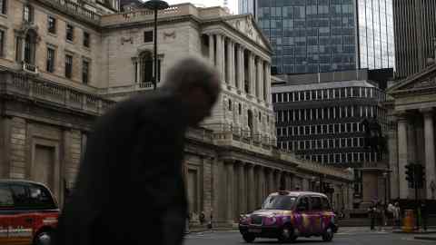 A London taxi drives past the Bank of England