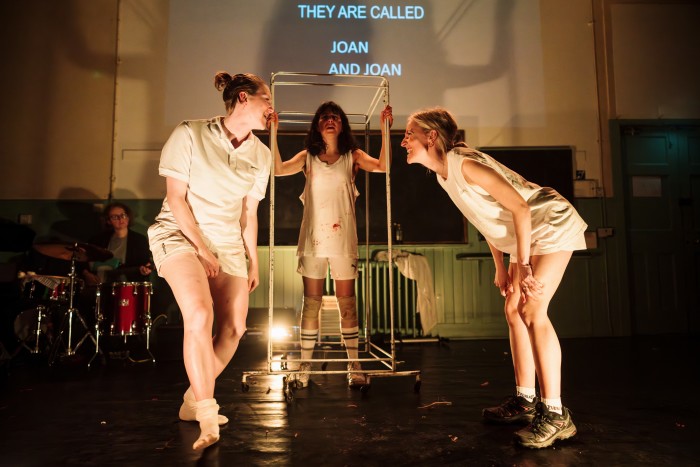 Three women dance while a drummer plays at the back of the stage