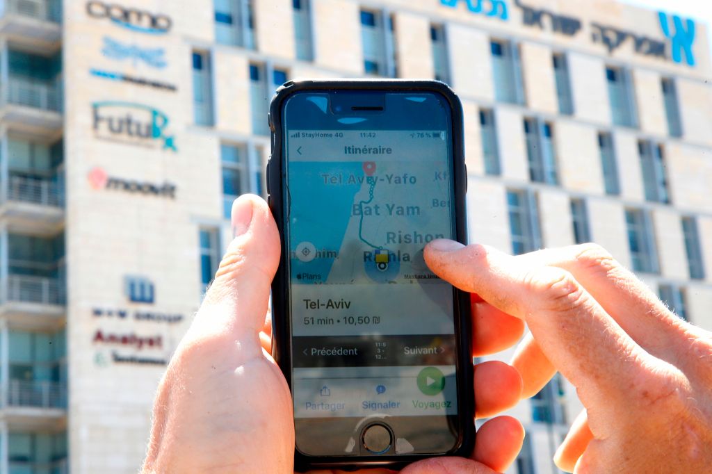 A man checks on his phone the Moovit mobile transport application in the central Israeli city of Ness Ziona on May 4, 2020. (Photo by JACK GUEZ / AFP) (Photo by JACK GUEZ/AFP via Getty Images)