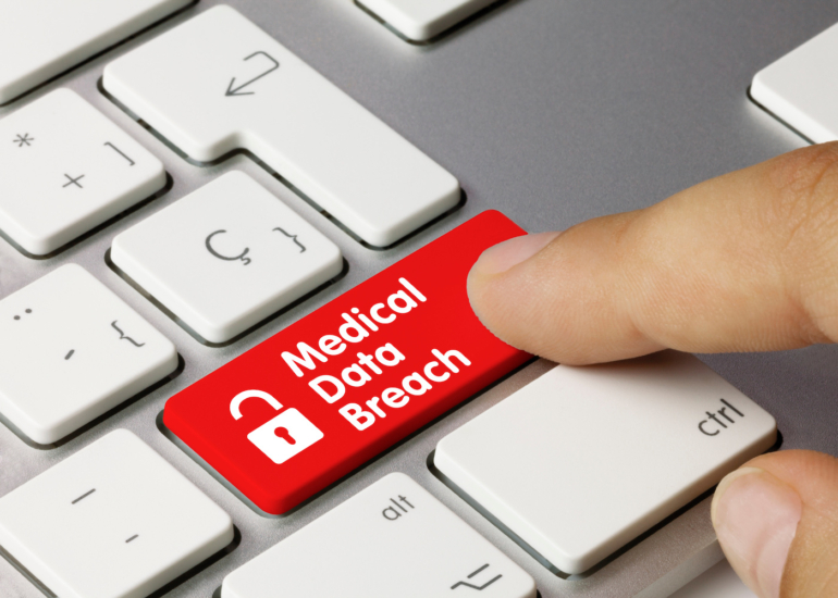 A red Medical Data Breach button on a laptop keyboard.