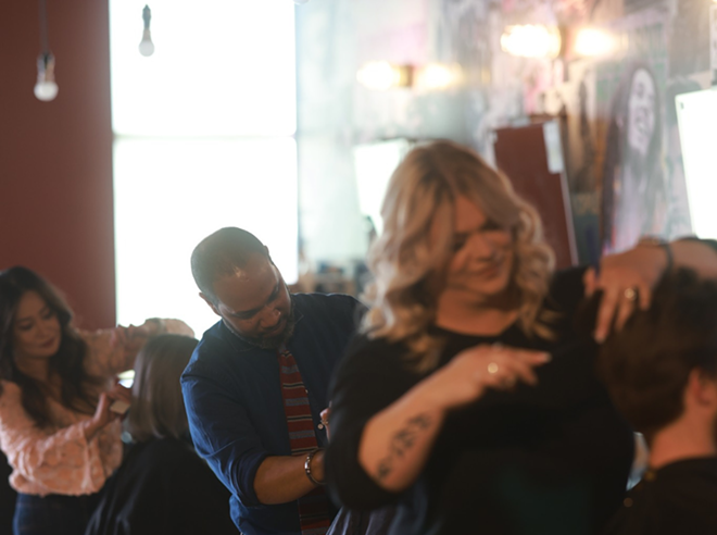 Hairstylist cut hair inside a Floyd's 99 Barbershop. - Facebook / Floyd's 99 Barbershop