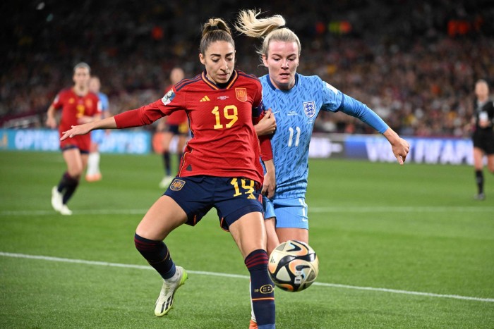 Spain’s defender Olga Carmona, left, fights for the ball with England forward Lauren Hemp