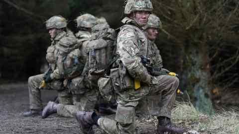 Soldiers training wearing camouflage fatigues and helmets