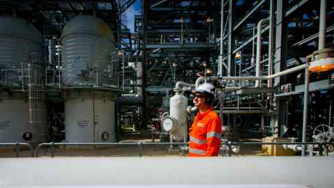 A worker walks past a gas pipe marked ‘methane’ at the Curtis Island liquefied natural gas plant in Gladstone, Australia