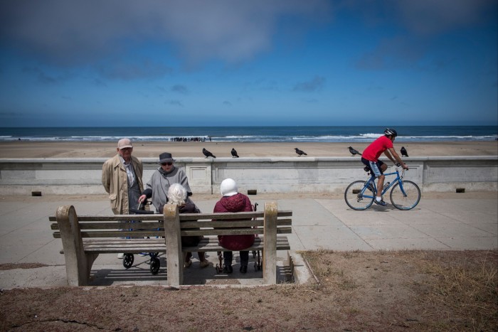 Elderly people talk on Ocean Beach in San Francisco. Taxing the incomes of younger workers to pay for healthcare and state benefits for older citizens is unlikely to be politically sustainable