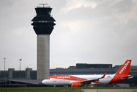 A plane taxis past a control tower at Manchester airport