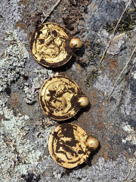 Handout photo released on September 7, 2023 by the Museum of Archaeology and the University of Stavanger (UiS), south-western Norway, shows coin-like gold pendants that are part of a gold treasure found in August 2023 by an amateur archaeologist with the help of a metal detector on the island of Rennesoy in Stavanger. The treasure consists of nine gold medallions and pearls that once formed a luxurious necklace, as well as three gold rings, the University of Stavanger announced on September 7, 2023. It was discovered at the end of August on a farmer's property near Stavanger by an amateur archaeologist, Erlend Bore, who had bought a metal detector after his doctor and physiotherapist advised him to be more physically active. (Photo by Erlend BORE / NTB / AFP) / Norway OUT (Photo by ERLEND BORE/NTB/AFP via Getty Images)