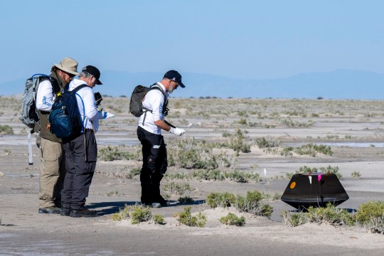 In this photo provided by NASA, from left, NASA Astromaterials Curator Francis McCubbin, NASA Sample Return Capsule Science Lead Scott Sandford and University of Arizona Osiris-Rex Principal Investigator Dante Lauretta, collect data next to the sample return capsule from NASA's Osiris-Rex mission after it landed at the Department of Defense's Utah Test and Training Range on Sunday, Sept. 24, 2023. The sample was collected from the asteroid Bennu in October 2020. (Keegan Barber/NASA via AP)