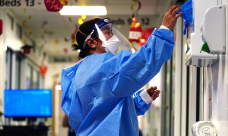 Nurse putting on full PPE on a ward for Covid patients at King’s College Hospital, in south east London.