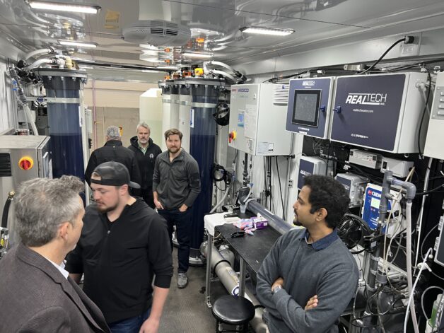 A group of people standing around equipment.