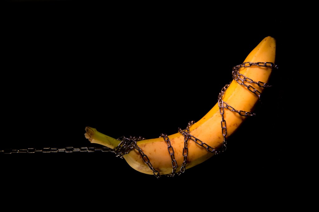 A banana chained on black background.