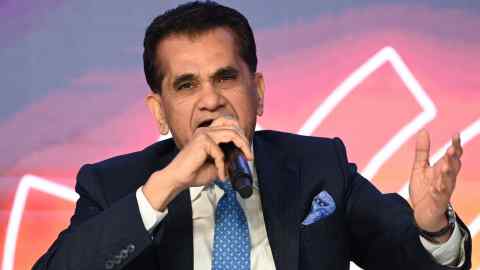 Amitabh Kant gestures as he speaks into a microphone