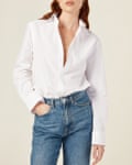 White shirt by British brand With Nothing Underneath, worn by model with faded blue jeans