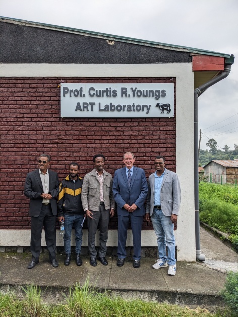 Curtis Youngs posing with group by lab sign bearing his name