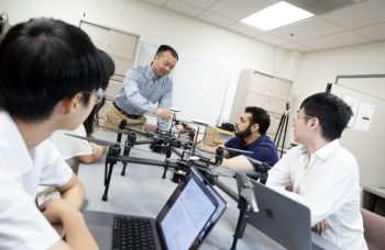 Group of researchers talking in a lab setting.