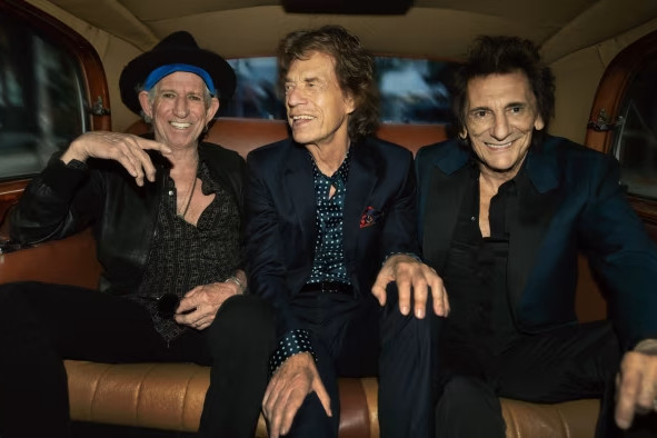 Keith Richards, Mick Jagger and Ronnie Wood in the backseat of a car