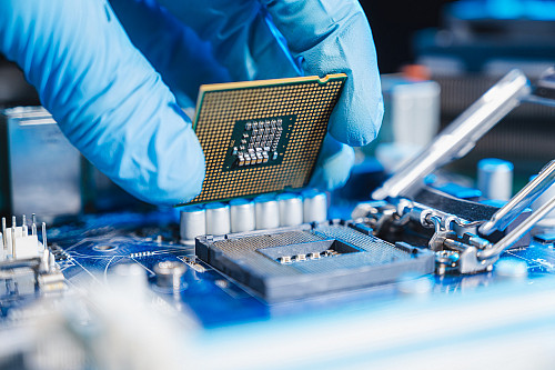 the technician laying CPU in the motherboard socket