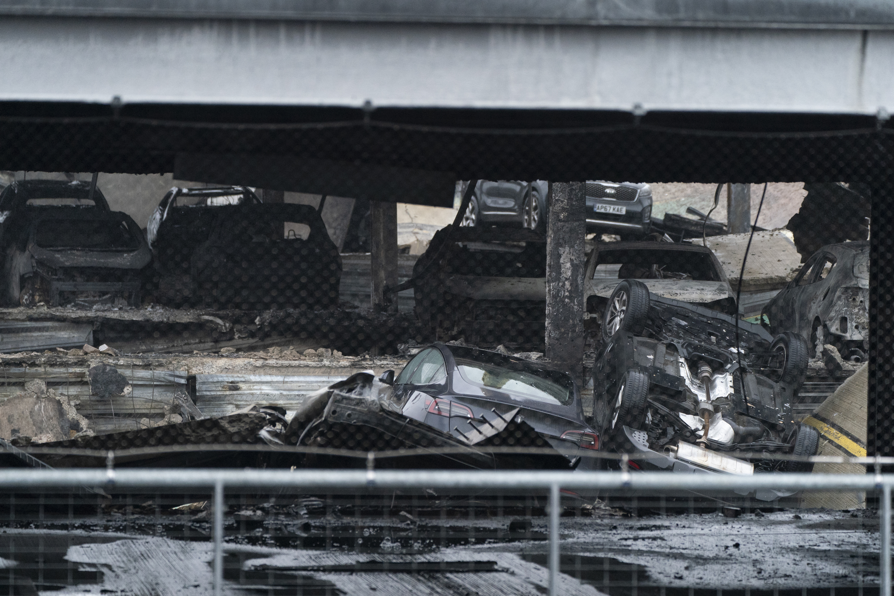 The shells of vehicles remain in Luton Airport's charred car park