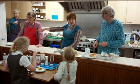 Schoolchildren queue for free food at a warm bank provided by Camborne parish church, Cornwall, November 2022.