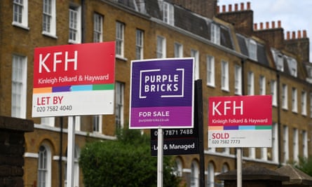 For sale signs in front of a row of houses