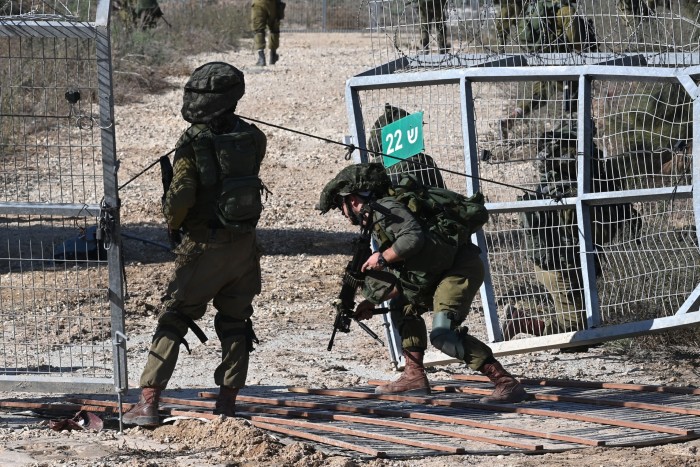 Israeli soldiers patrol a border fence with the Gaza Strip