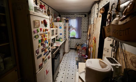 A galley kitchen with tiles missing from the wall