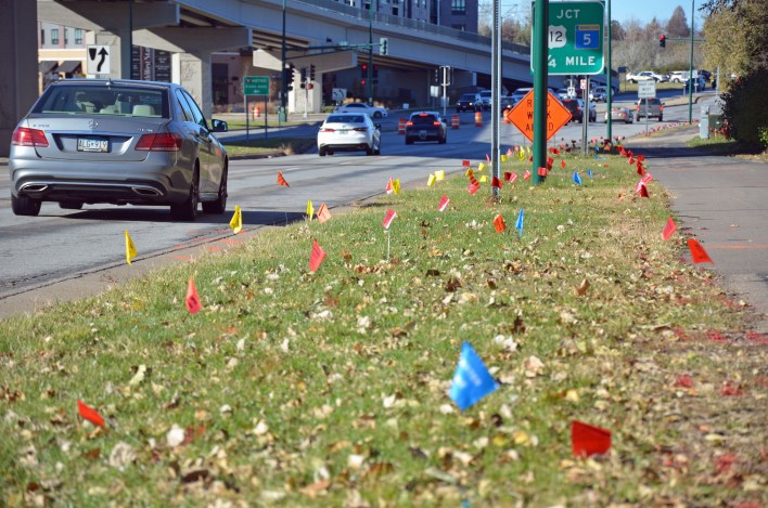 Colored flags marked the locations of buried utilities along Valley View Road near the light rail bridge. 