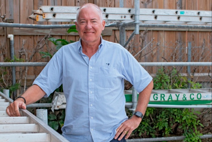 Roofing company founder Jonathan Gray, a man smiling for the camera while inside a garage