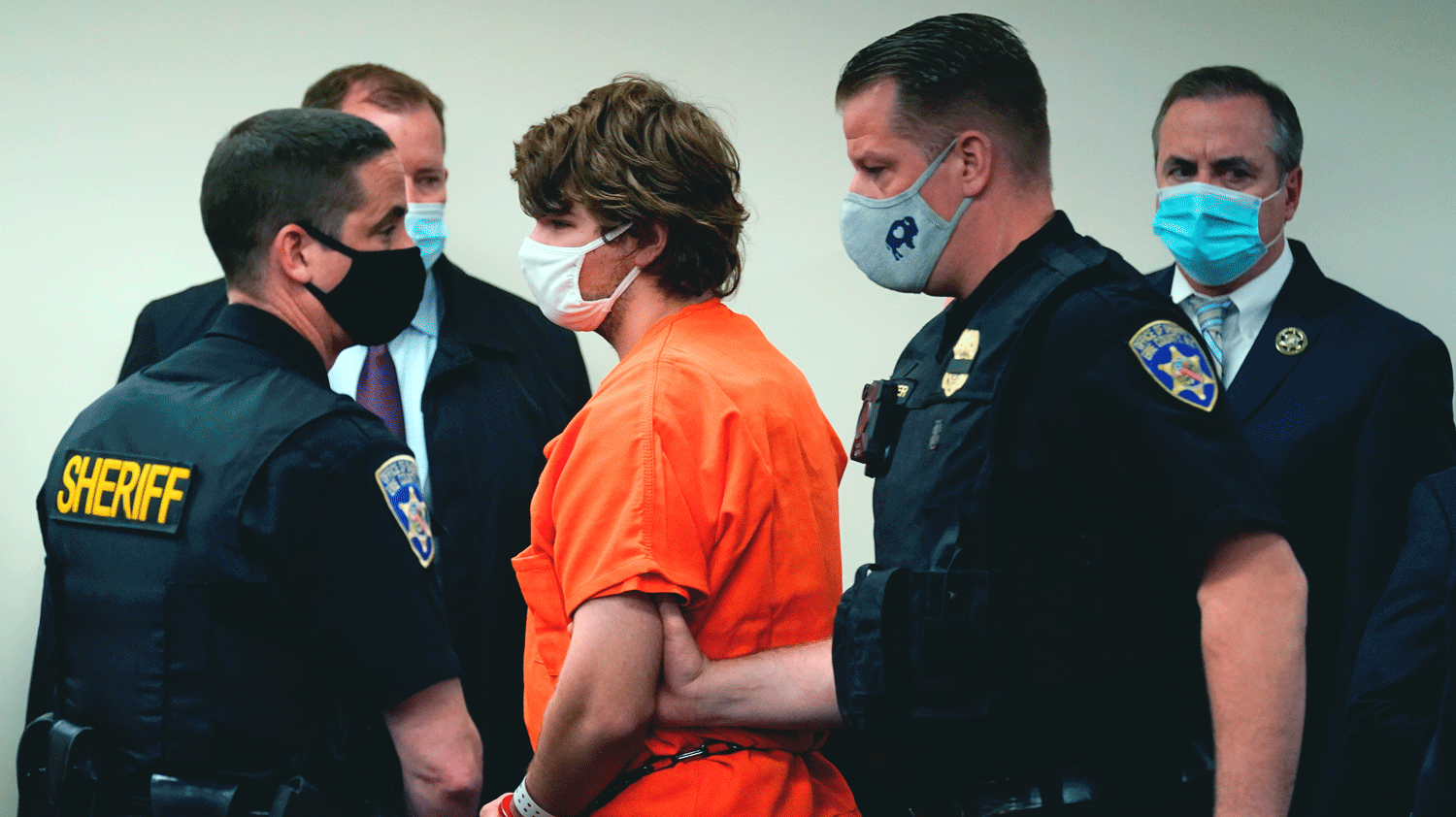 Shackled, wearing an orange jumpsuit and surrounded by law enforcement officers, Payton Gendron is led out of court in Buffalo, NY