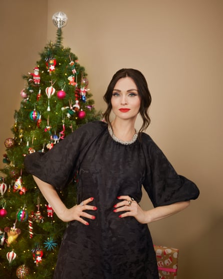 Sophie Ellis-Bextor in front of a Christmas tree wearing a black dress